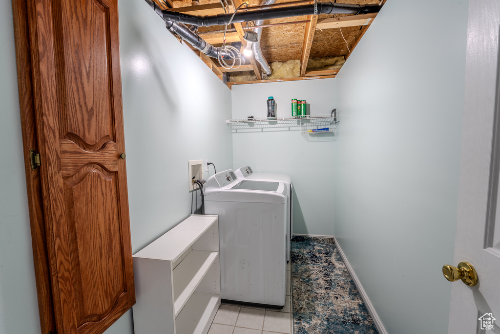 Washroom featuring baseboards, laundry area, washing machine and dryer, and light tile patterned floors
