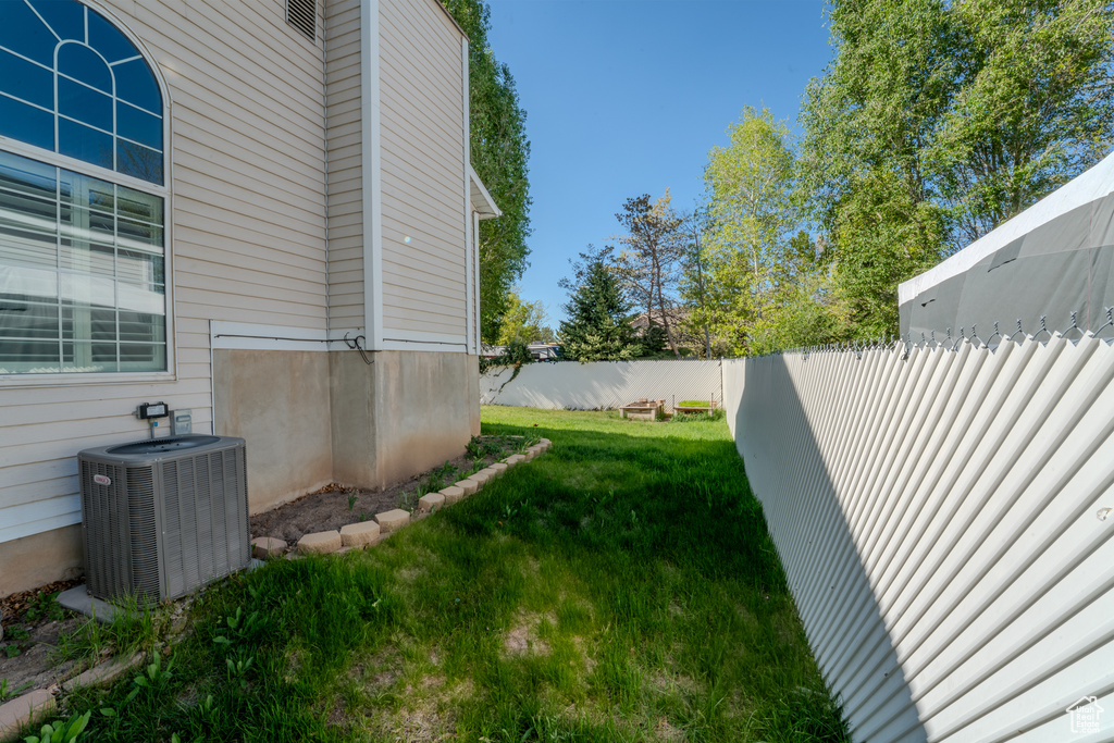 View of yard with a fenced backyard and central air condition unit