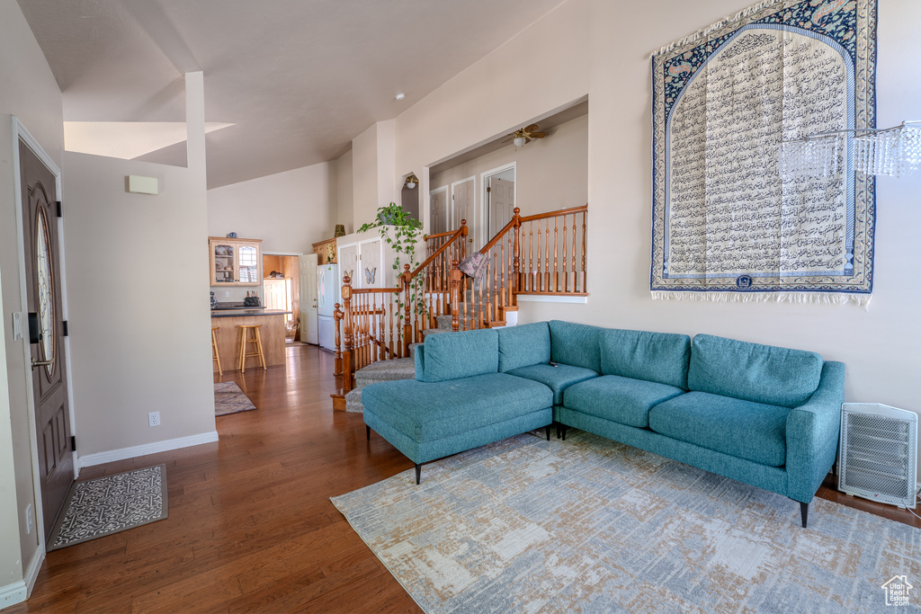 Living room featuring baseboards, a ceiling fan, stairs, and wood finished floors