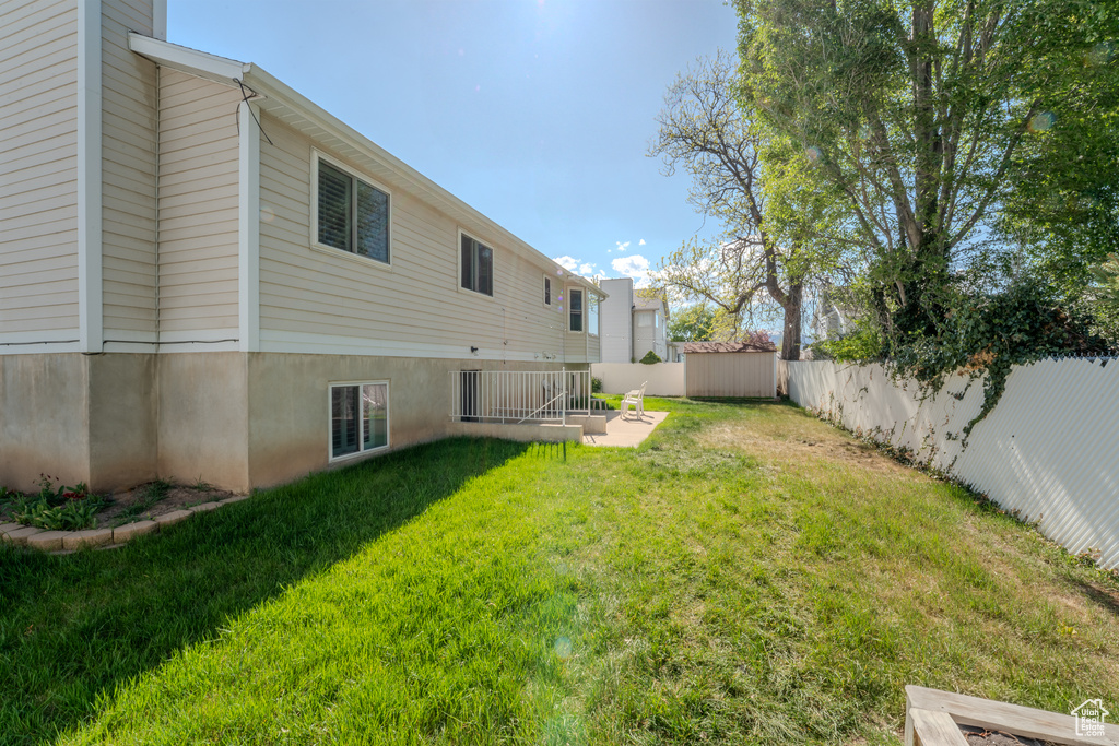 View of yard with a storage unit, a fenced backyard, and an outdoor structure