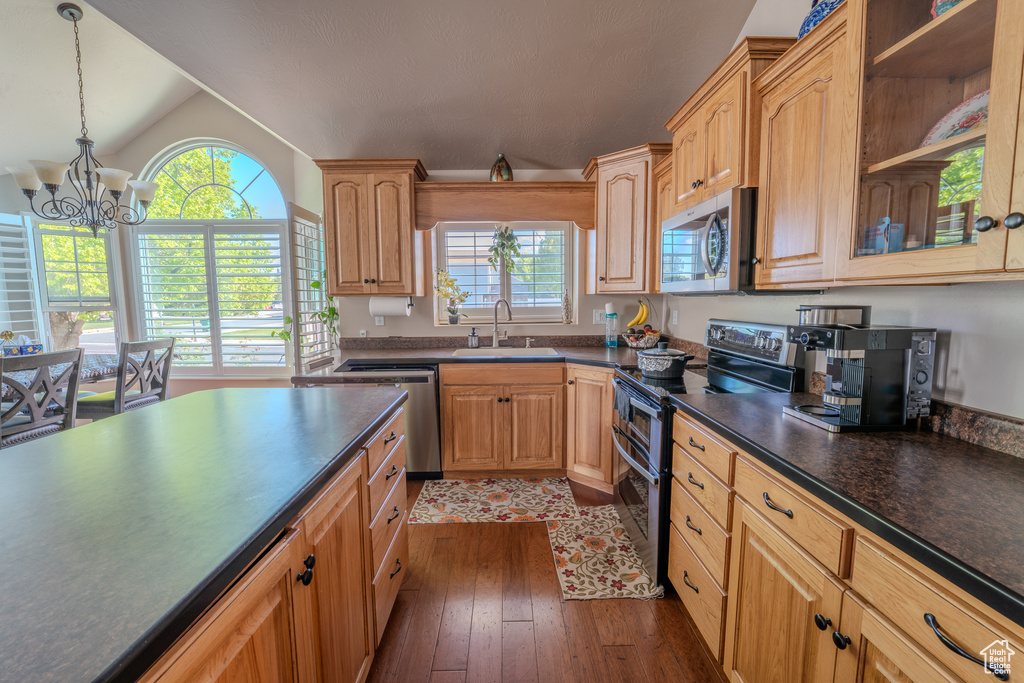 Kitchen featuring a sink, a healthy amount of sunlight, dark countertops, and stainless steel appliances