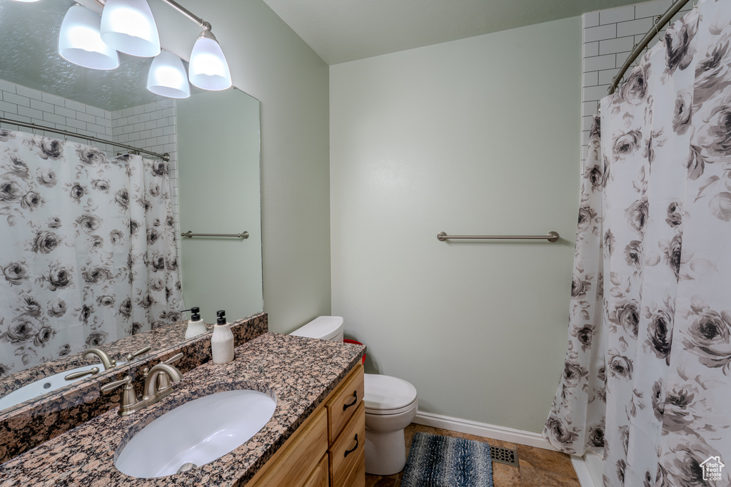 Bathroom featuring vanity, baseboards, a shower with curtain, and toilet