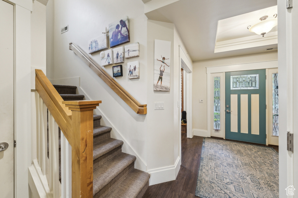 Entrance foyer with stairway, baseboards, and wood finished floors