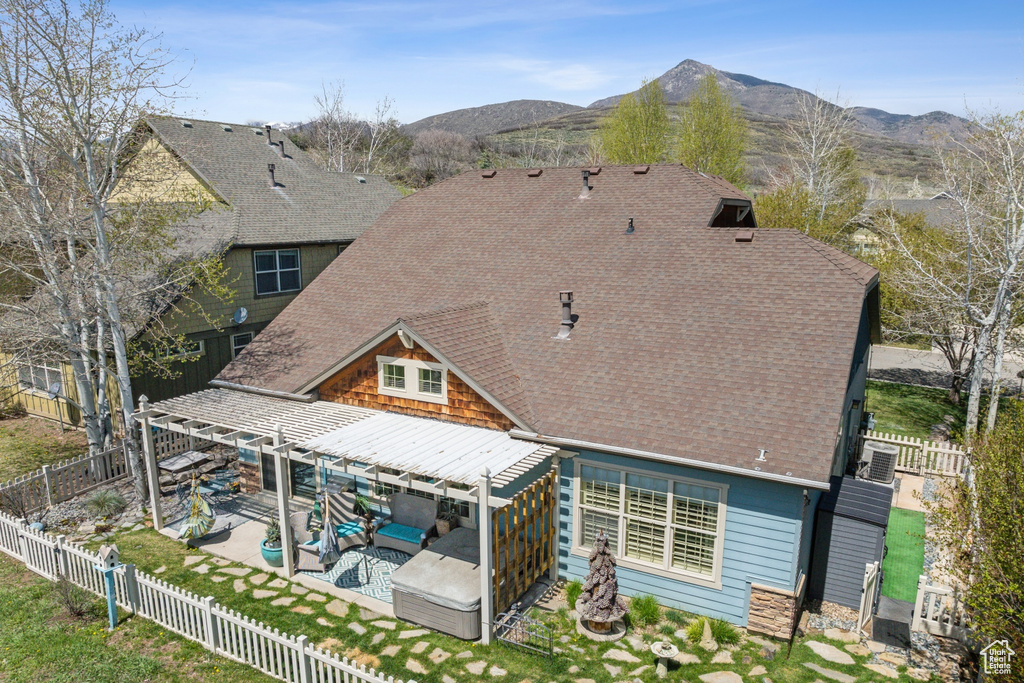 Rear view of house with a fenced backyard, an outdoor hangout area, a shingled roof, and a patio