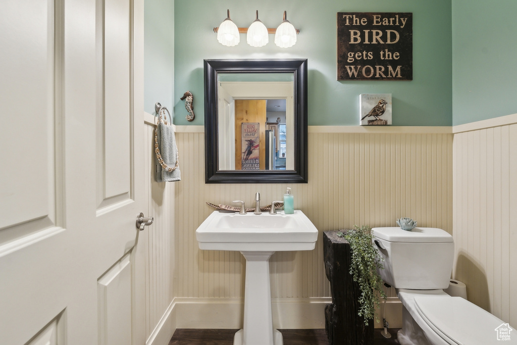 Bathroom with a sink, wainscoting, and toilet