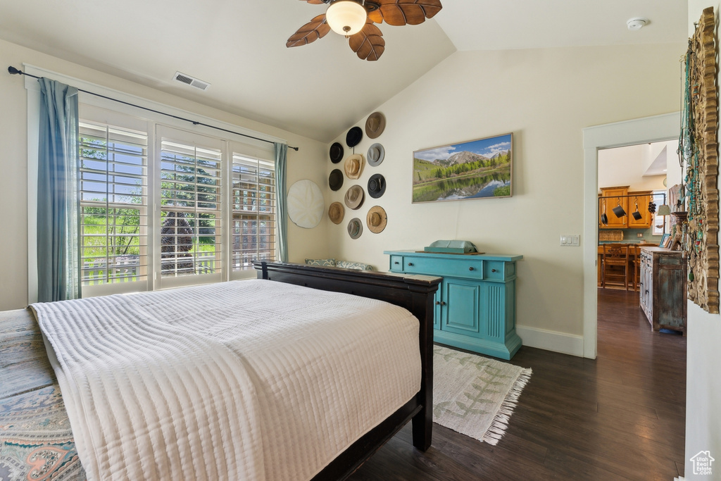 Bedroom with vaulted ceiling, dark wood finished floors, ceiling fan, and baseboards