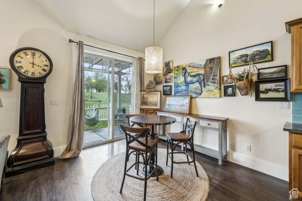 Dining area featuring baseboards, dark wood finished floors, and lofted ceiling
