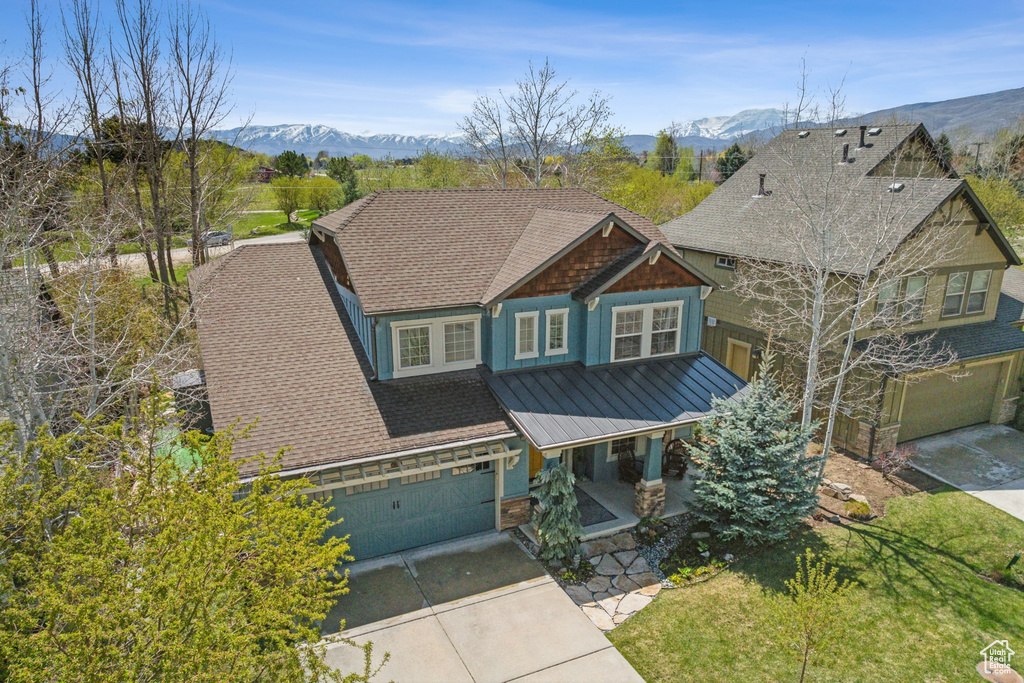 Craftsman house featuring a mountain view, covered porch, a standing seam roof, and concrete driveway