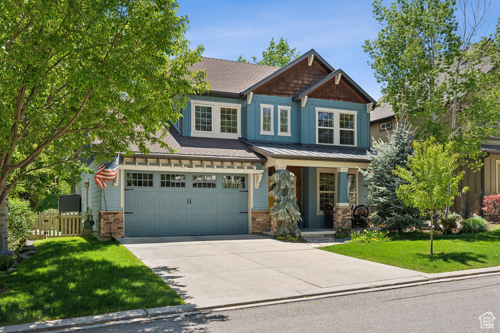 Craftsman-style house with driveway, a porch, a standing seam roof, a garage, and metal roof