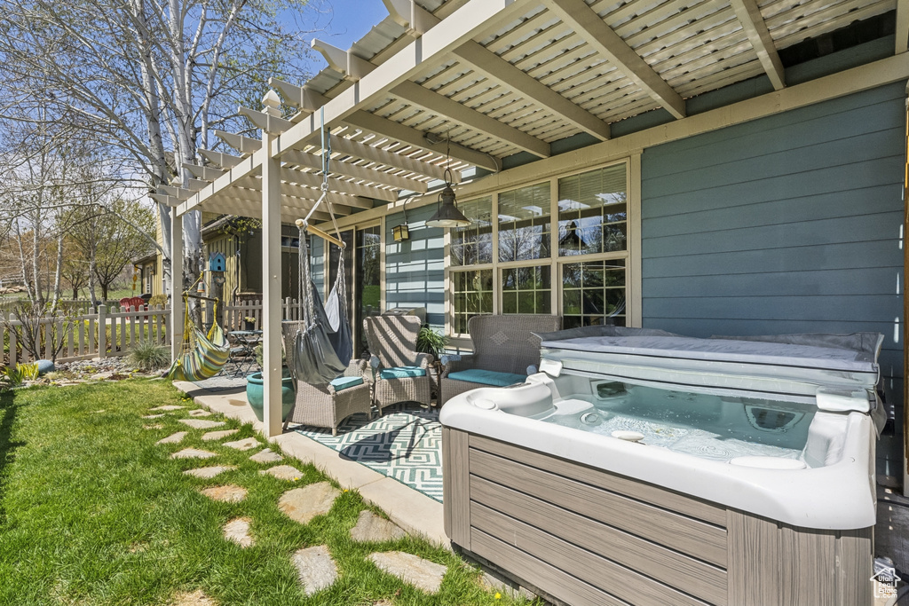 View of patio / terrace featuring a hot tub, fence, and a pergola