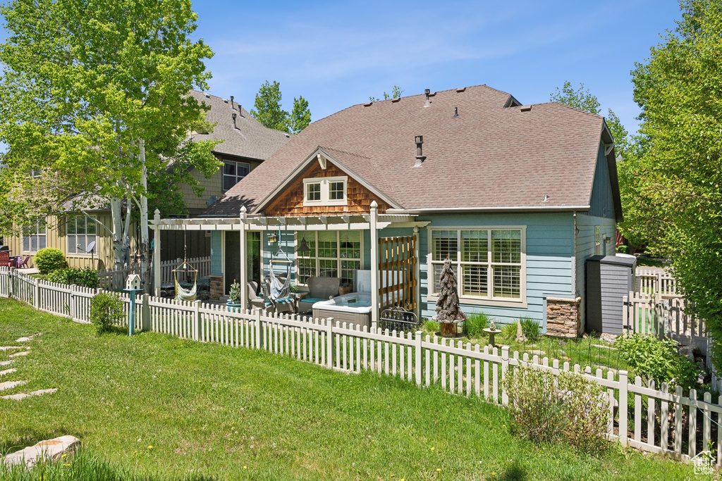Rear view of house featuring a shingled roof and a patio area