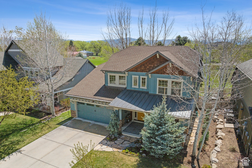 Craftsman inspired home featuring a porch, a standing seam roof, metal roof, driveway, and a garage