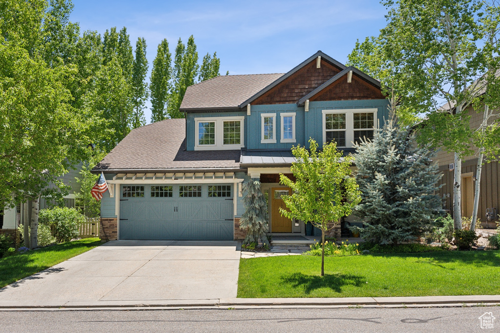 Craftsman house with concrete driveway, roof with shingles, and an attached garage