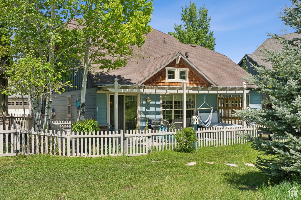 Rear view of property featuring roof with shingles and a pergola