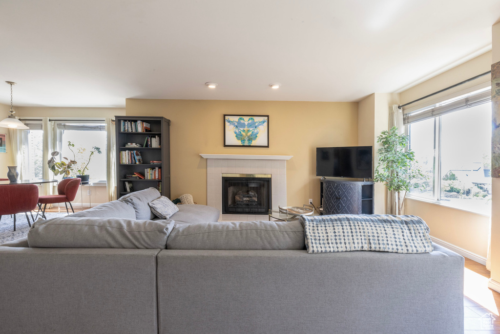 Living room with recessed lighting, a tile fireplace, a wealth of natural light, and baseboards