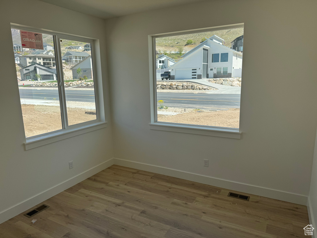 Unfurnished room with visible vents, baseboards, and a healthy amount of sunlight