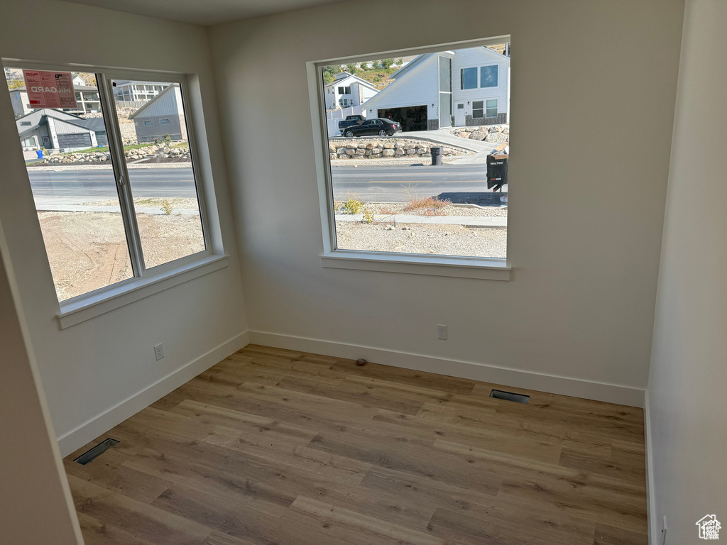 Unfurnished dining area with baseboards, visible vents, and wood finished floors
