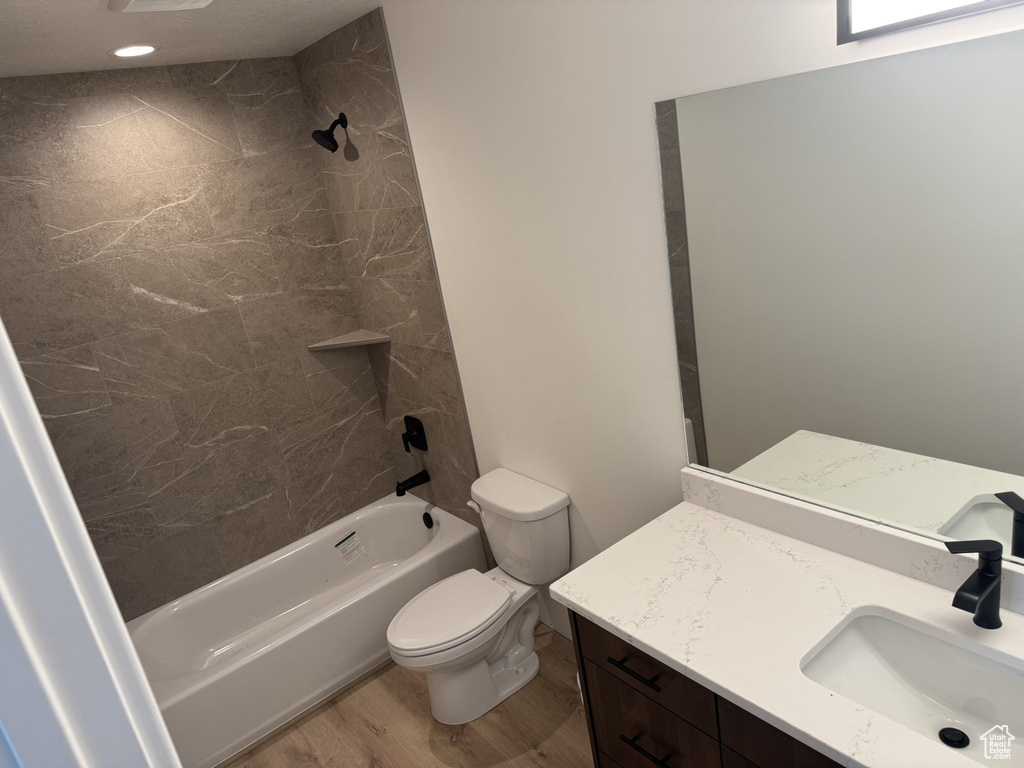 Full bath featuring vanity, tub / shower combination, wood finished floors, and toilet