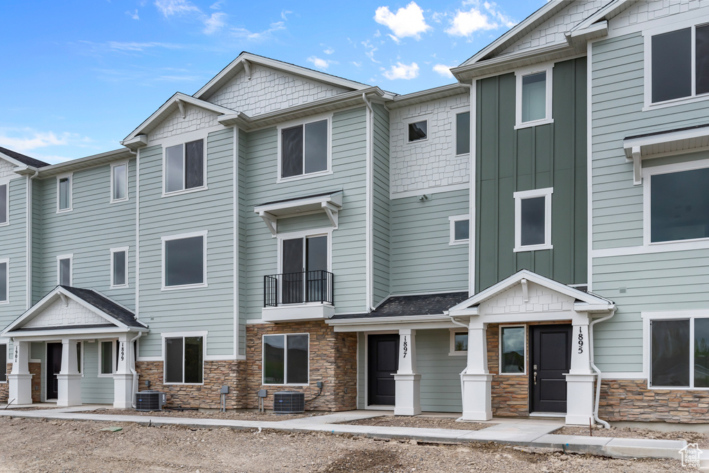 Multi unit property featuring board and batten siding, cooling unit, and stone siding