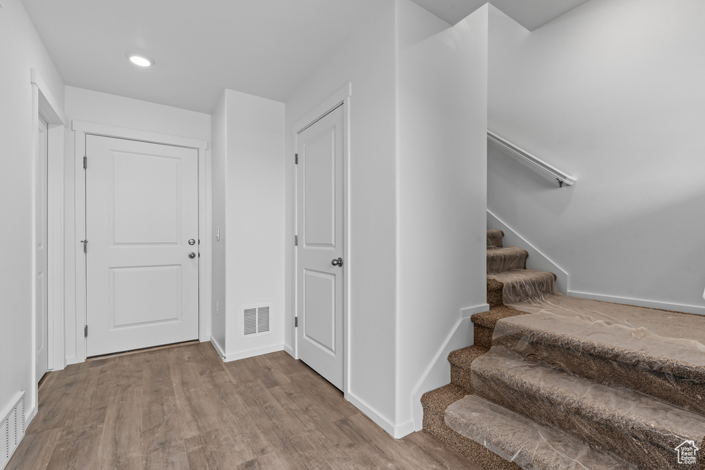 Interior space featuring stairs, baseboards, visible vents, and wood finished floors