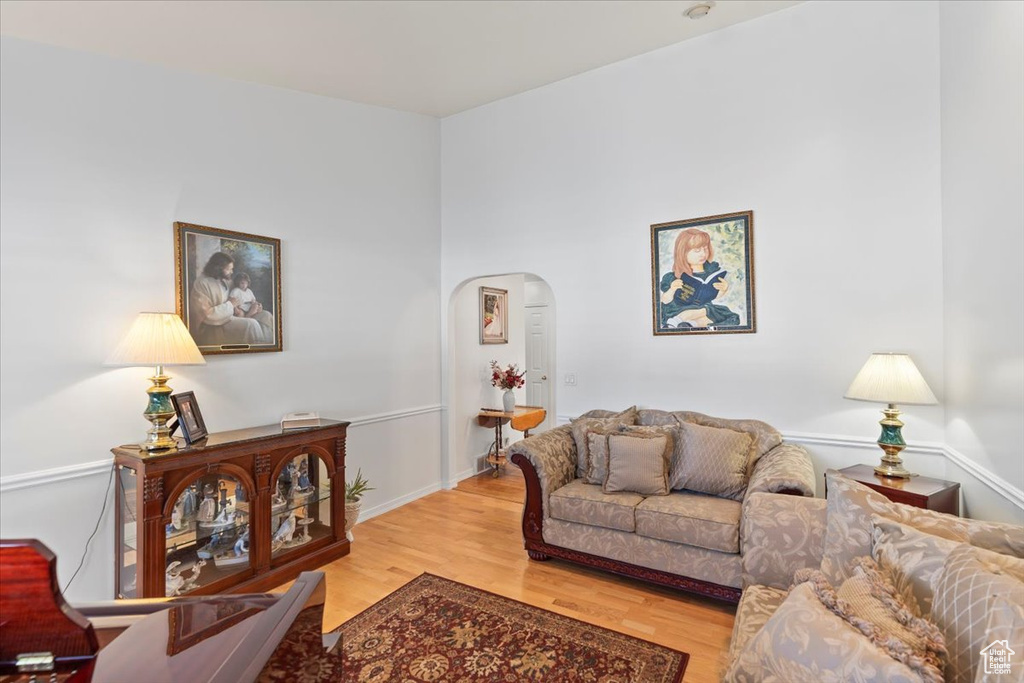 Living room with arched walkways and light wood-style flooring