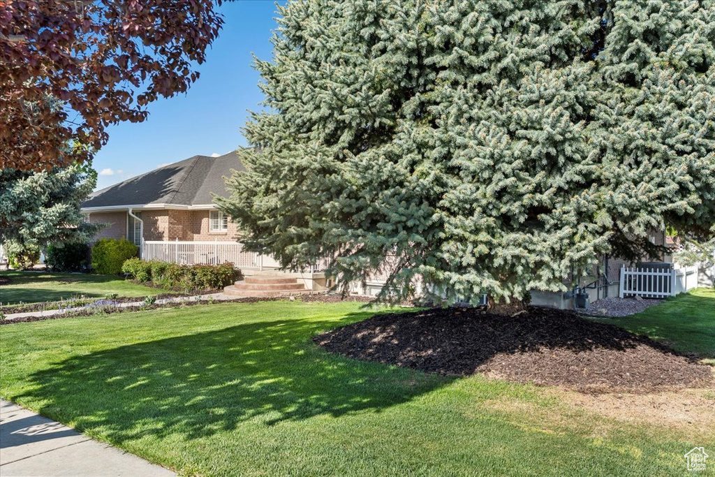 Exterior space with brick siding and a yard