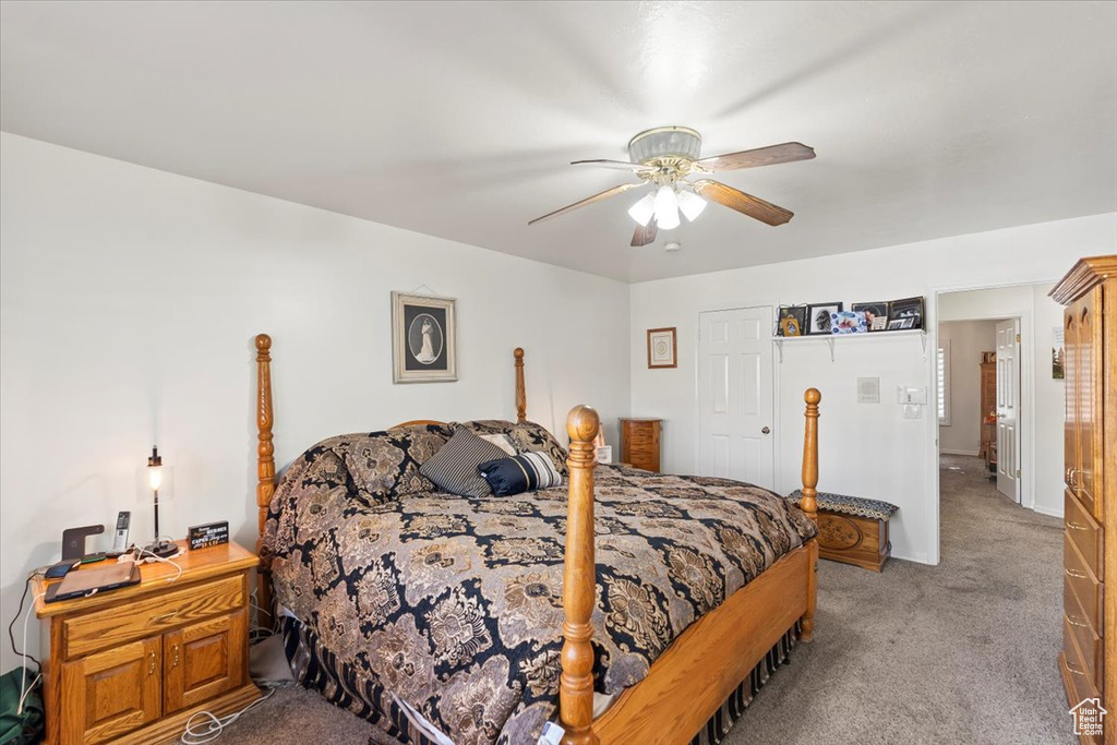 Carpeted bedroom featuring a ceiling fan