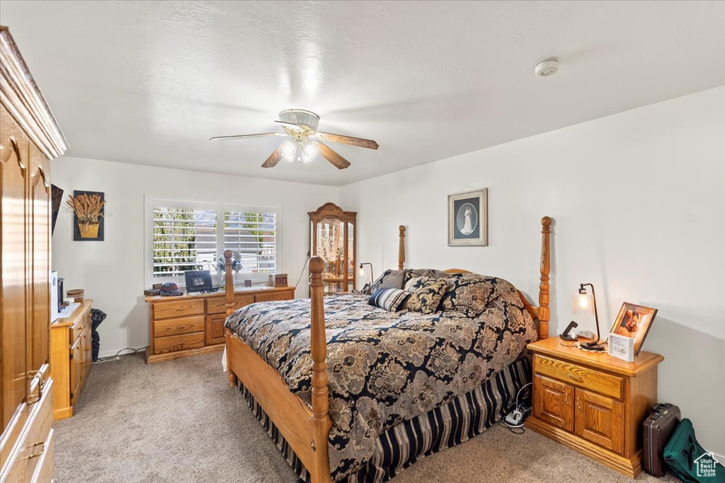 Bedroom with a ceiling fan and light carpet