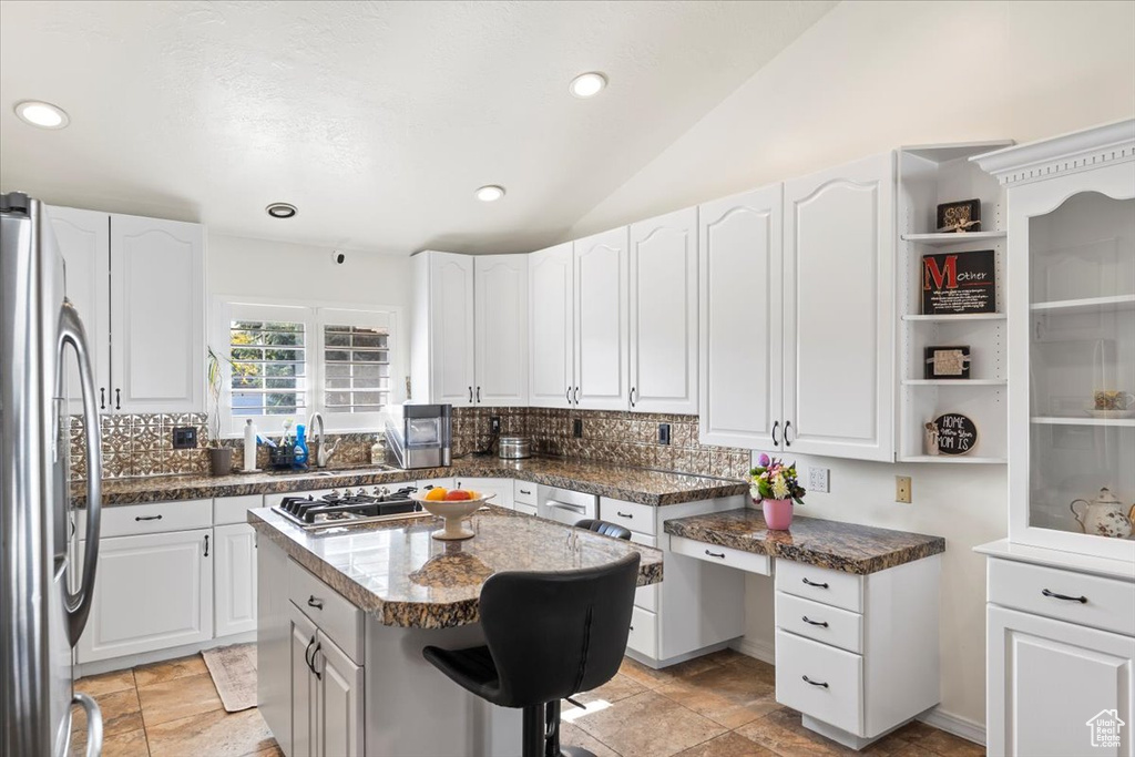 Kitchen with a kitchen island, stainless steel appliances, recessed lighting, and white cabinetry