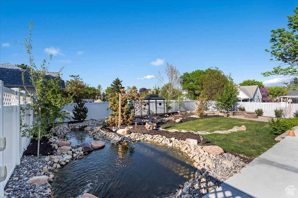 View of yard featuring a small pond and a fenced backyard