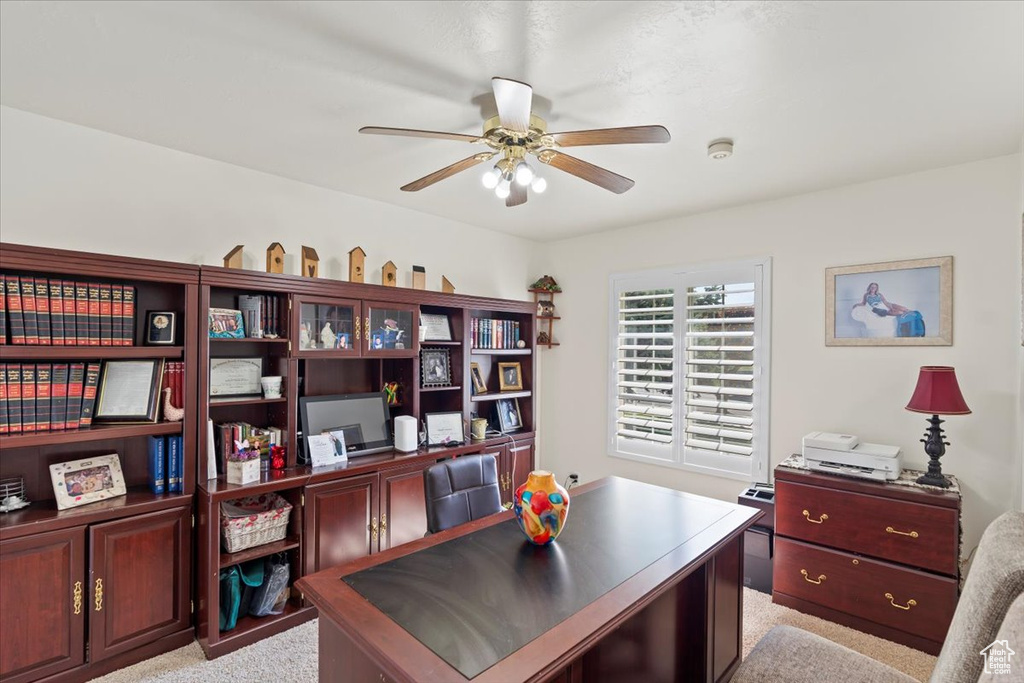 Office space featuring a ceiling fan and light colored carpet
