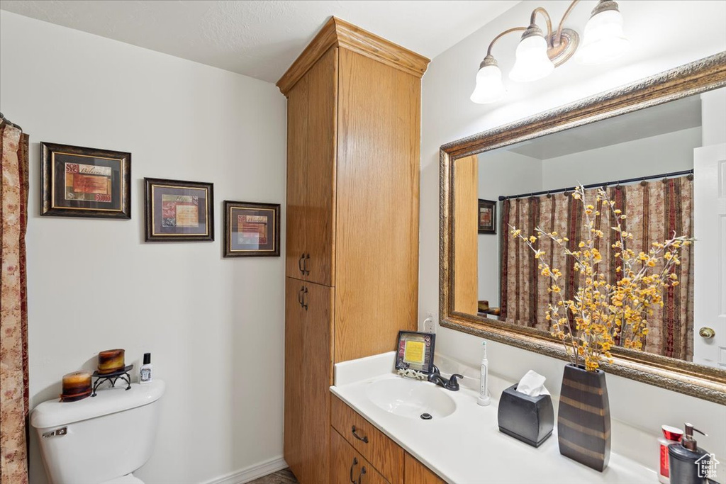 Full bath featuring toilet, baseboards, and vanity