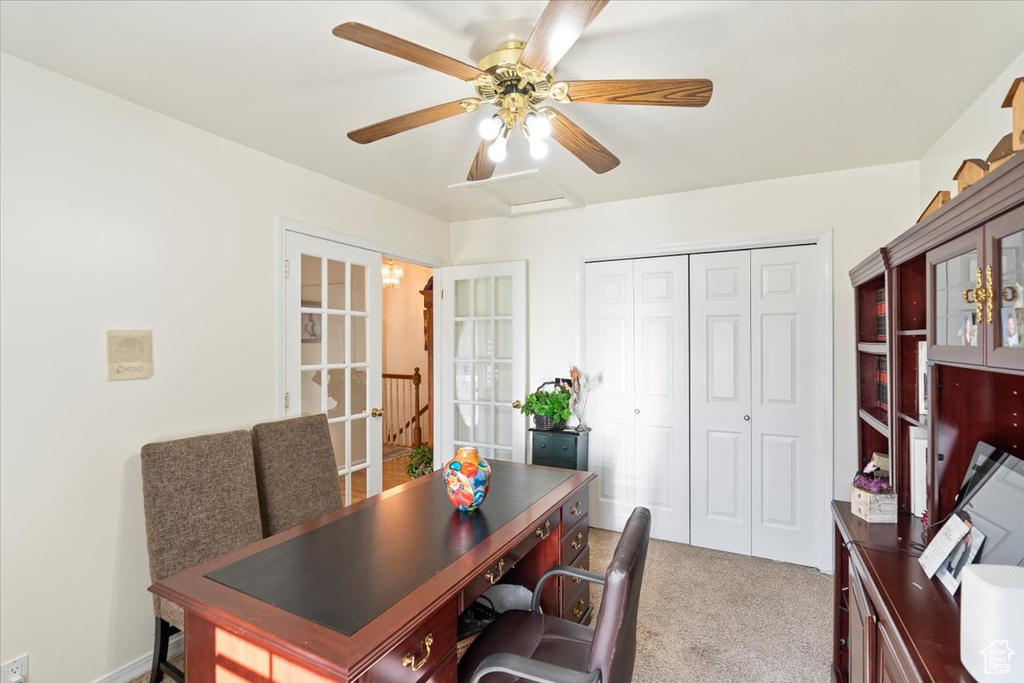 Carpeted office space featuring french doors and a ceiling fan