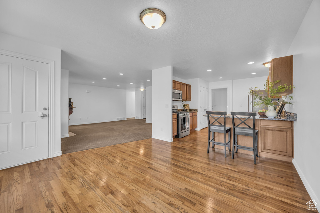 Living room featuring recessed lighting, baseboards, visible vents, and light wood-style floors