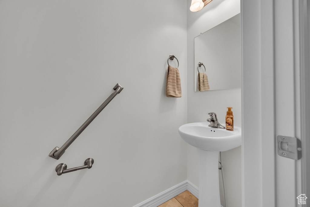 Bathroom with baseboards, a sink, and tile patterned flooring