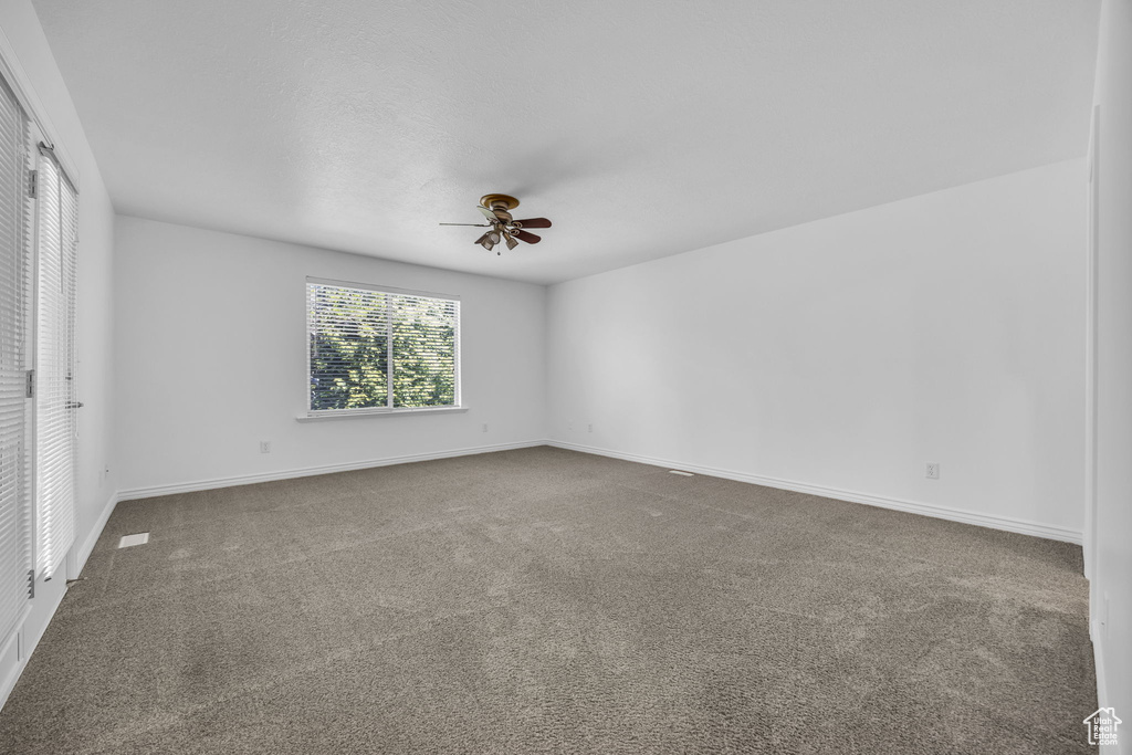 Unfurnished bedroom with carpet floors, baseboards, and ceiling fan