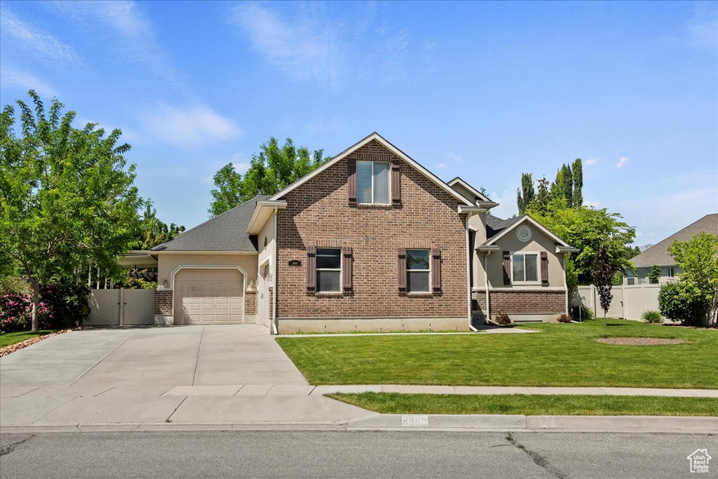 View of front facade with a garage, concrete driveway, and brick siding
