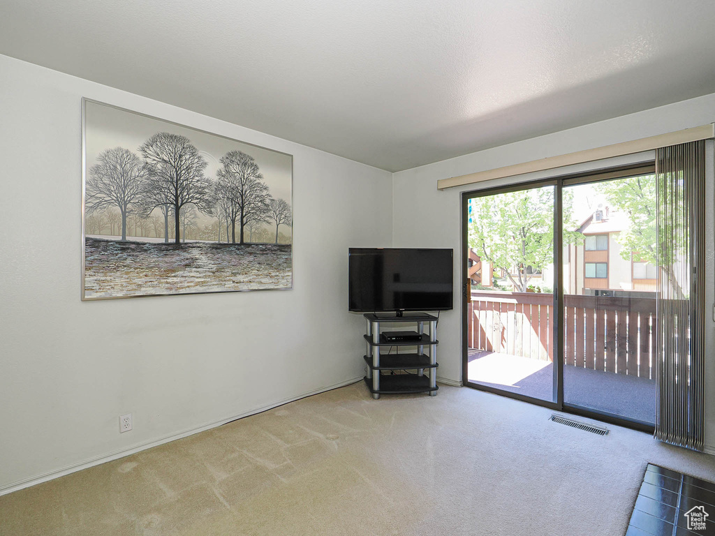 Carpeted living area with baseboards and visible vents