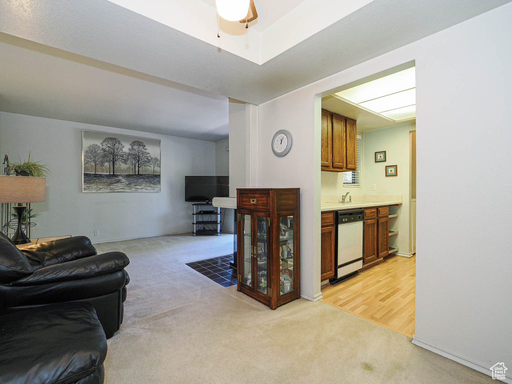 Living area with ceiling fan and light carpet