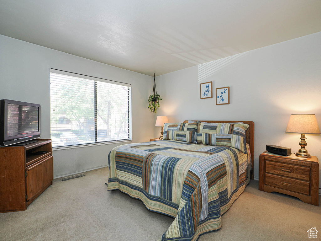 Bedroom featuring visible vents, baseboards, and light carpet