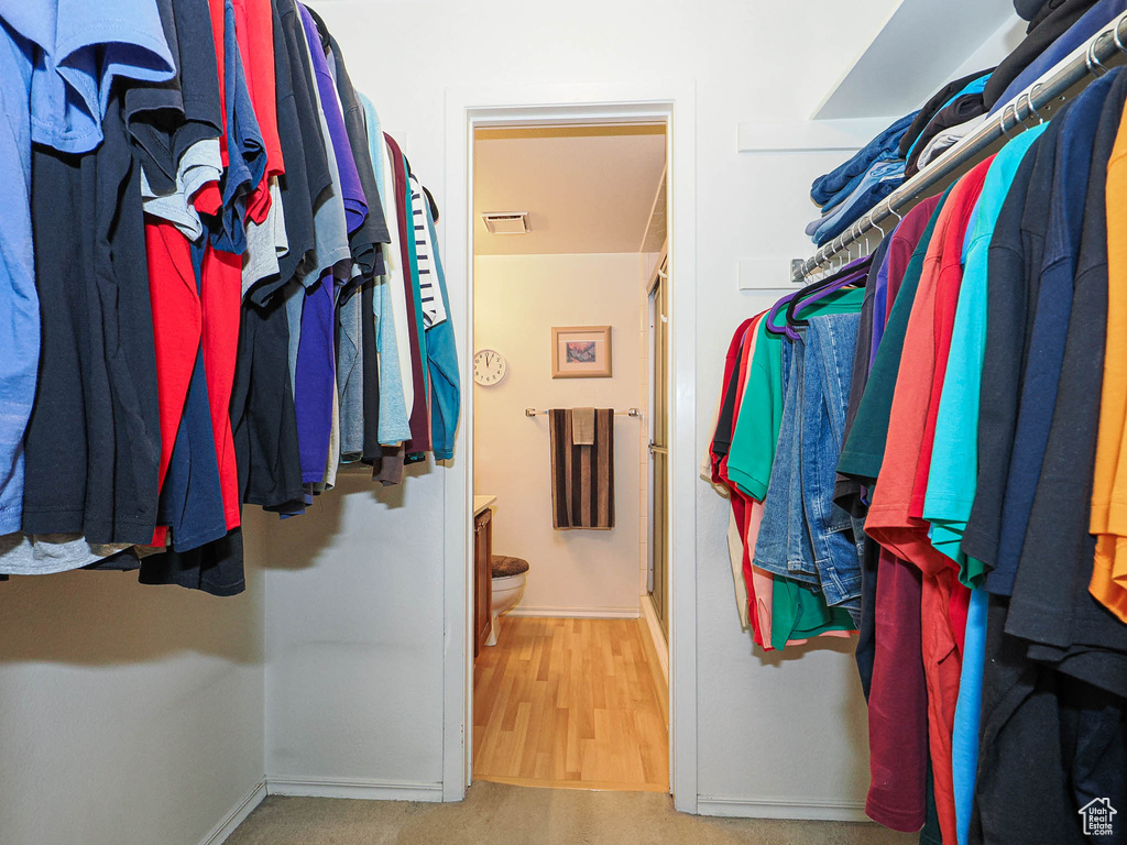 Walk in closet featuring visible vents and wood finished floors