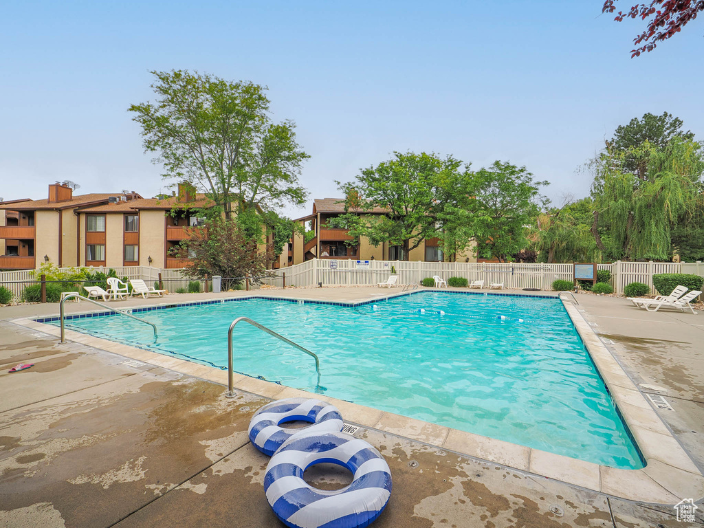 Community pool featuring a patio and fence