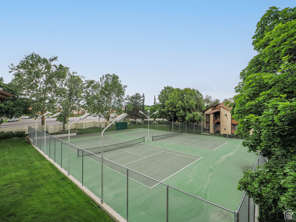 View of tennis court featuring a yard and fence