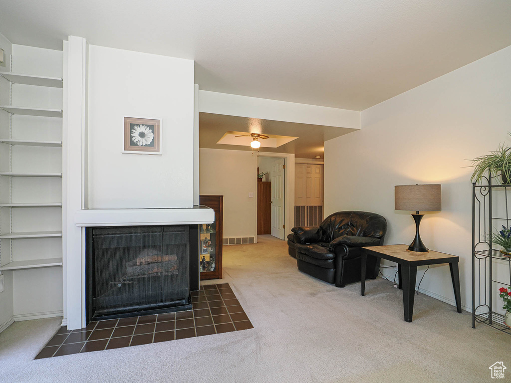 Carpeted living room featuring baseboards, visible vents, and a fireplace