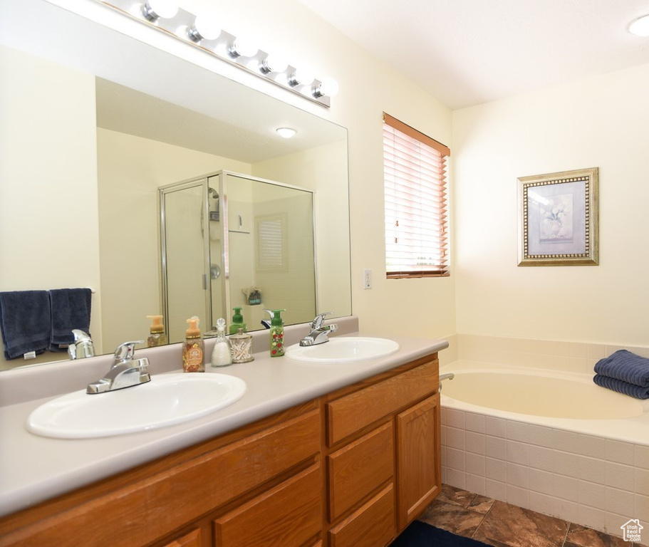 Full bath featuring double vanity, a sink, a bath, and a stall shower