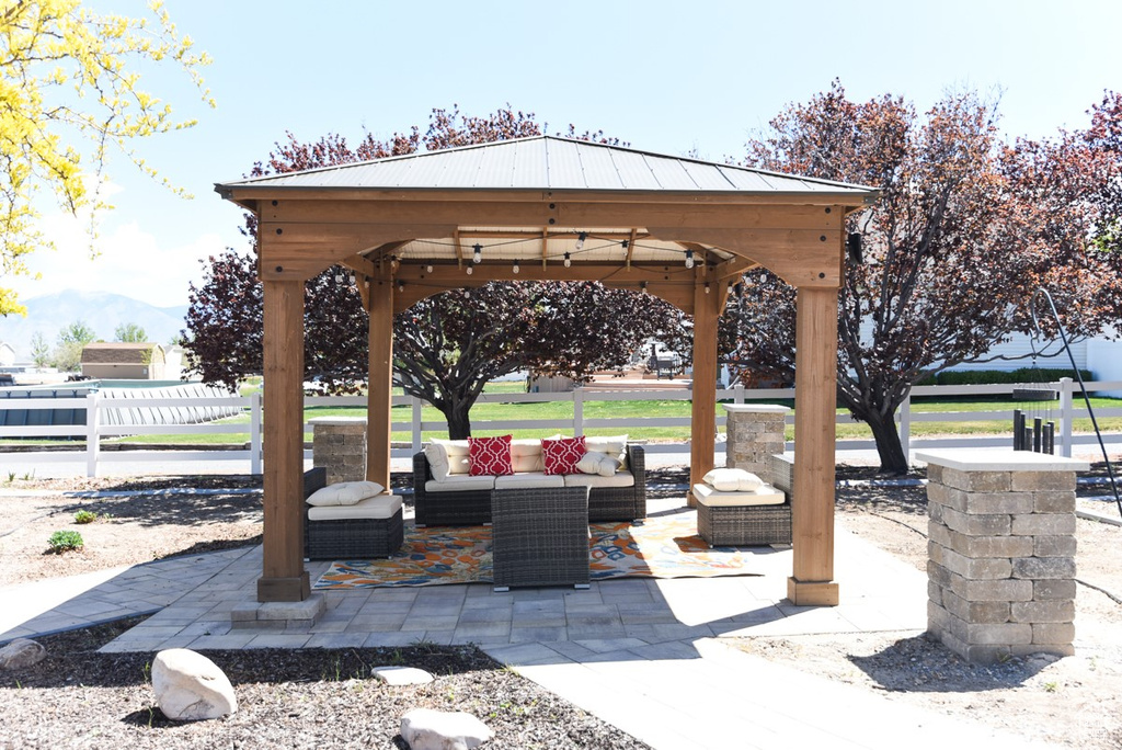 View of patio with a gazebo, fence, and an outdoor hangout area