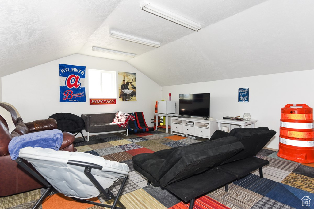 Carpeted living area featuring vaulted ceiling