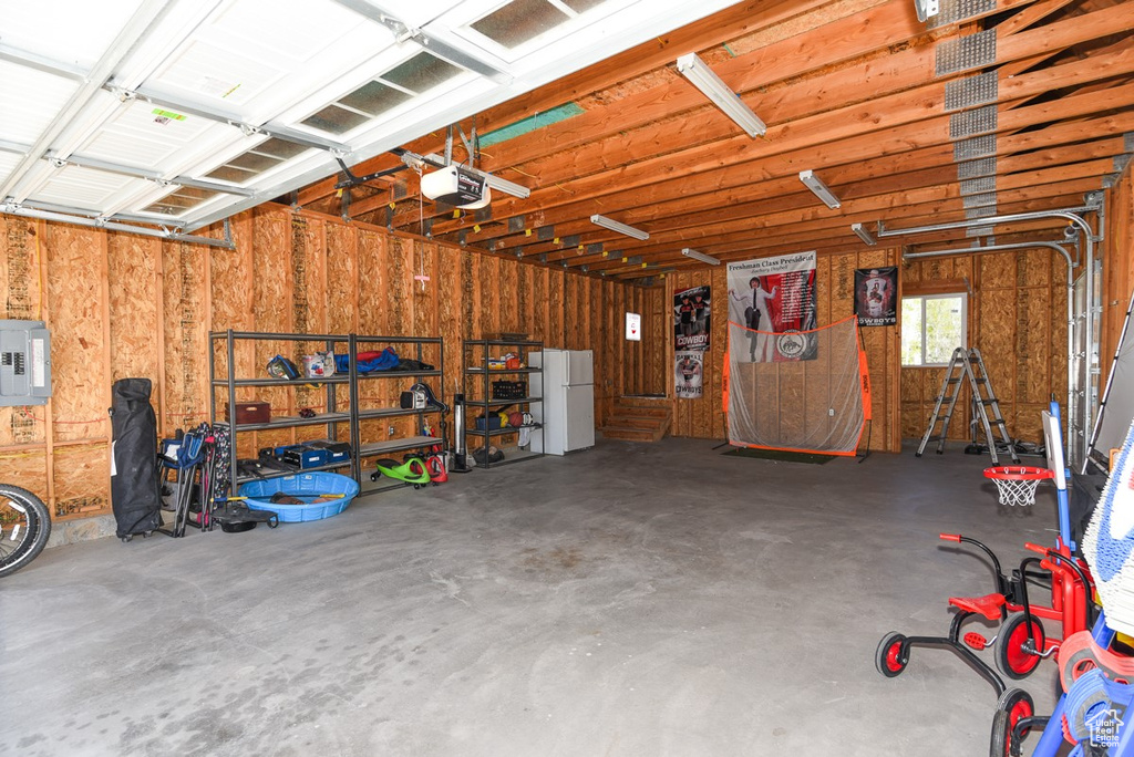 Garage with a garage door opener and freestanding refrigerator