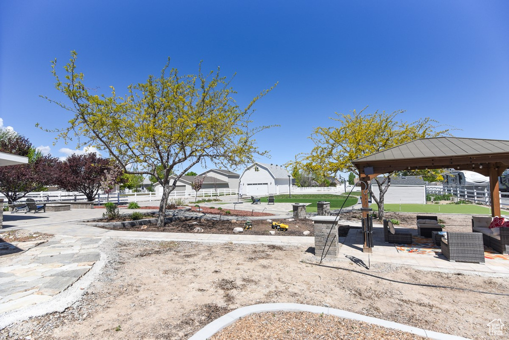 View of yard featuring fence, a gazebo, an outdoor living space, and a patio area