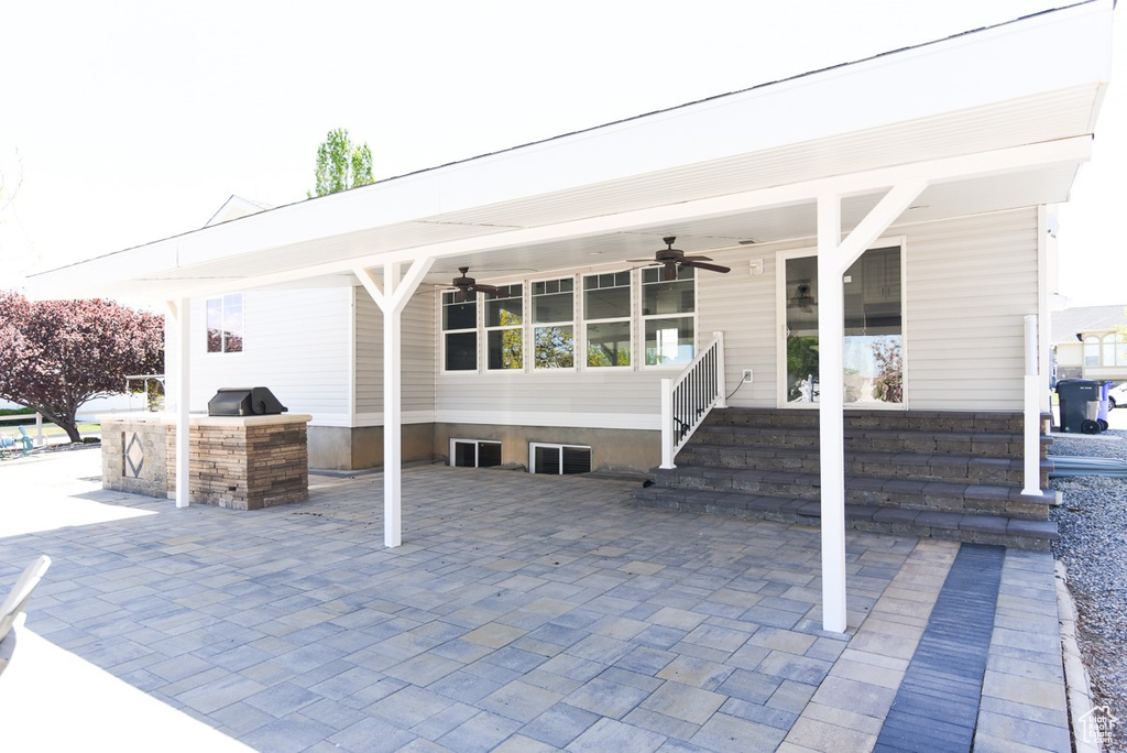 View of patio with exterior kitchen and ceiling fan